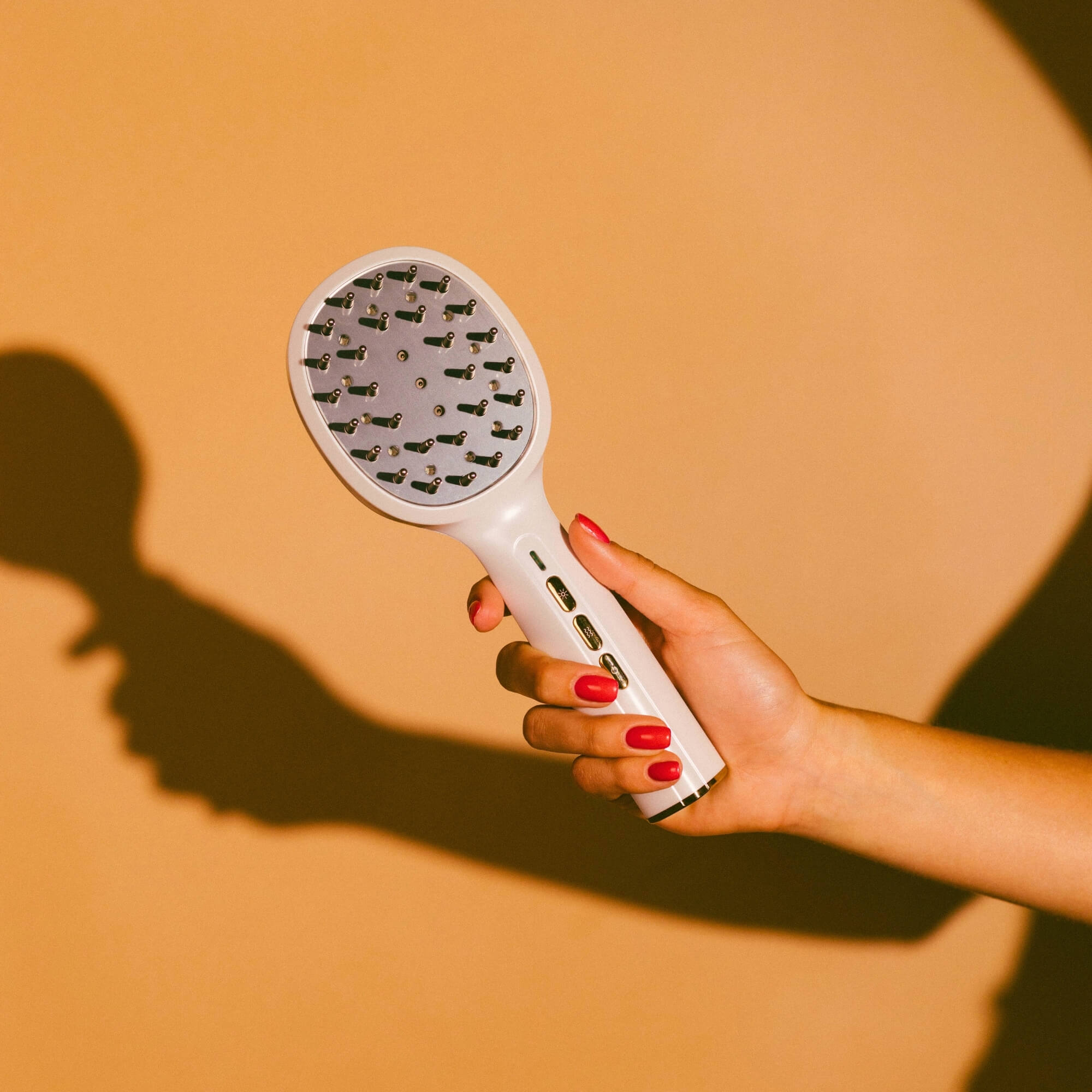 Масажираща LED четка за коса - Scalp Expert с изключени светлини, държана от ръка.